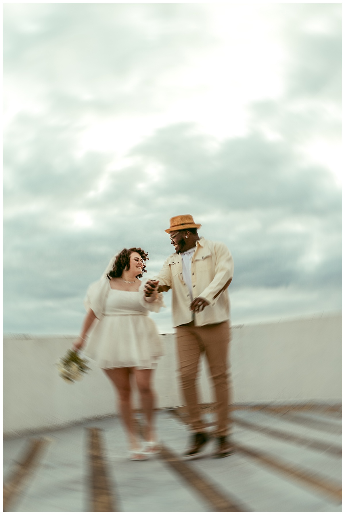 couple holds hands on rooftop by Virginia Beach photographer