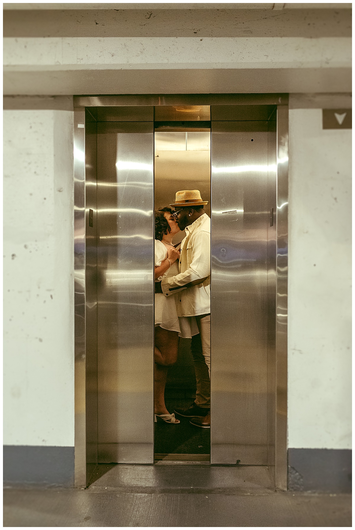 bride and groom kiss as elevator doors close during wedding portrait session