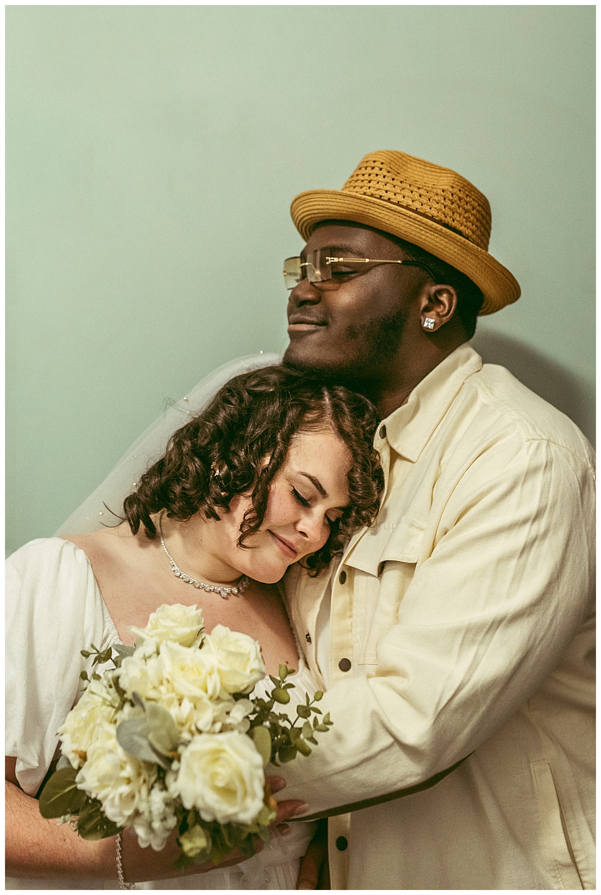 woman rests head on man's chest as they smile by Virginia Beach photographer