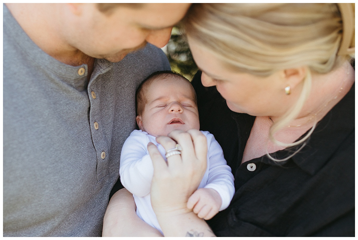 baby is held between parents by Nikki Meer Photography
