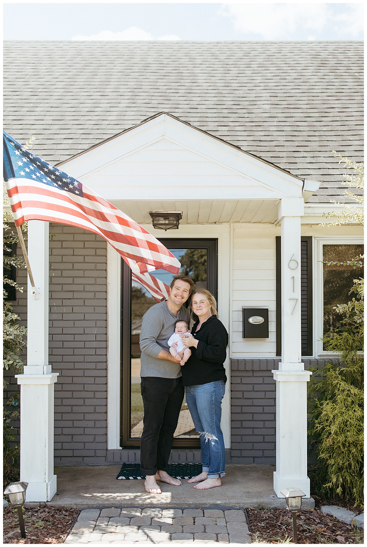 mom and dad hold baby on front porch to prepare for your in-home newborn session