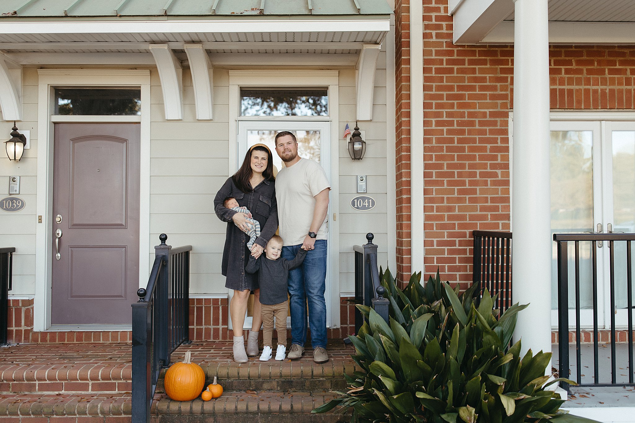 family gathers on front step of their home by Nikki Meer Photography