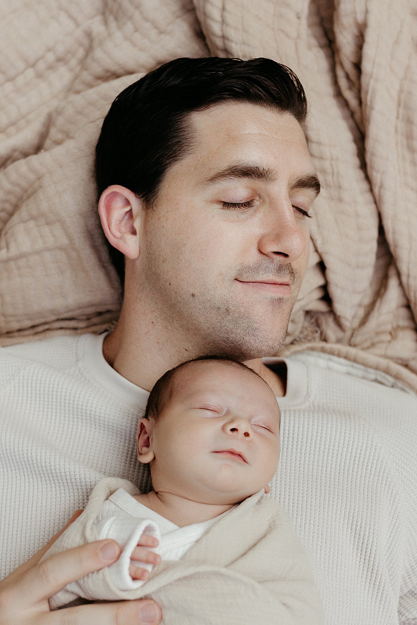 baby lays on dad's chest during neutral in-home newborn session