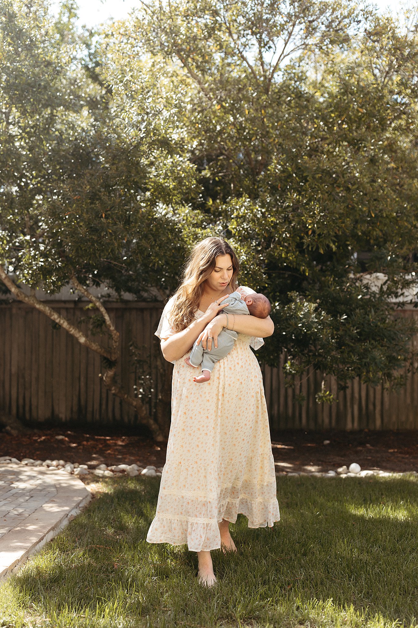 mom holds newborn outside by Virginia Beach photographer