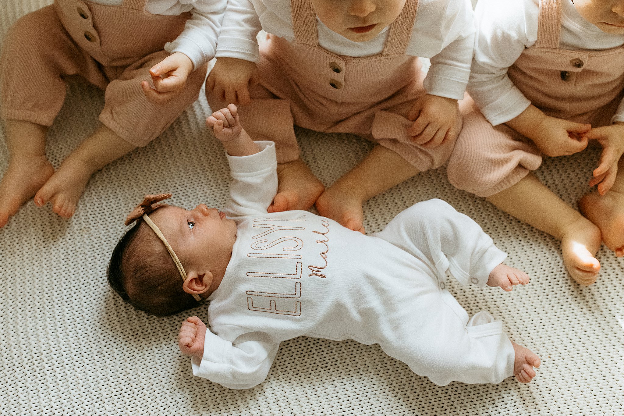 siblings gather around little sister during Newborn Lifestyle Session