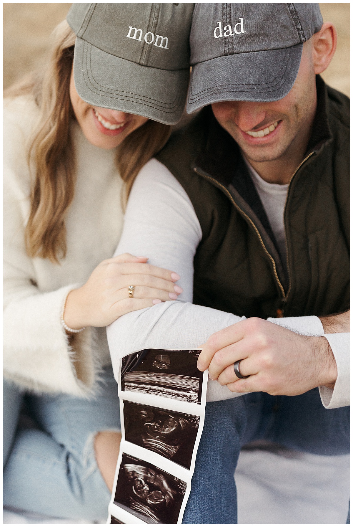 mom and dad to be lean heads together as they look at ultrasound by Virginia Beach photographer