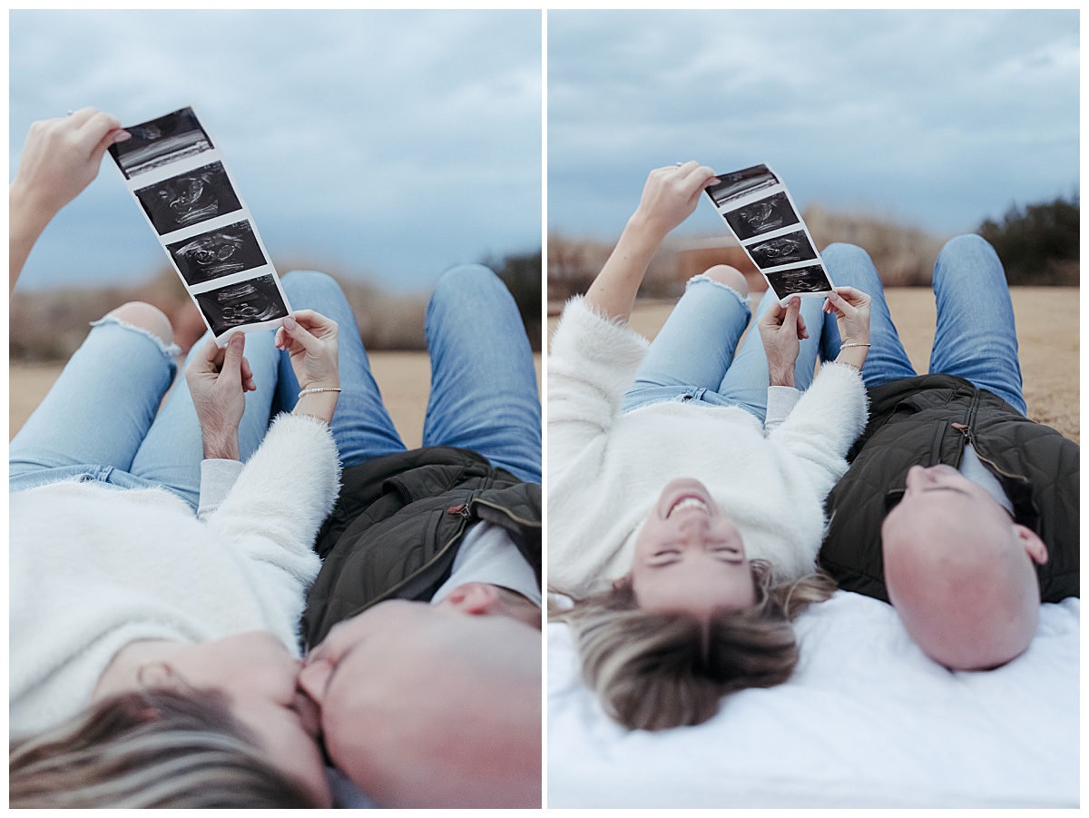 parents to be laugh together and kiss as they lay on a blanket together by Nikki Meer Photography