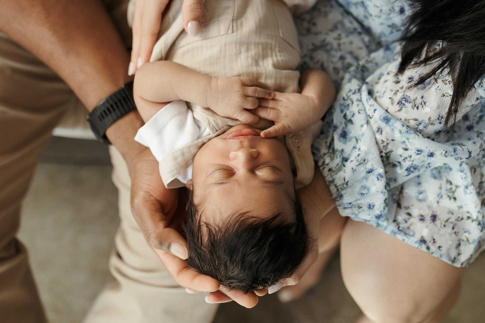 infant is cradled in parents hands during studio newborn session