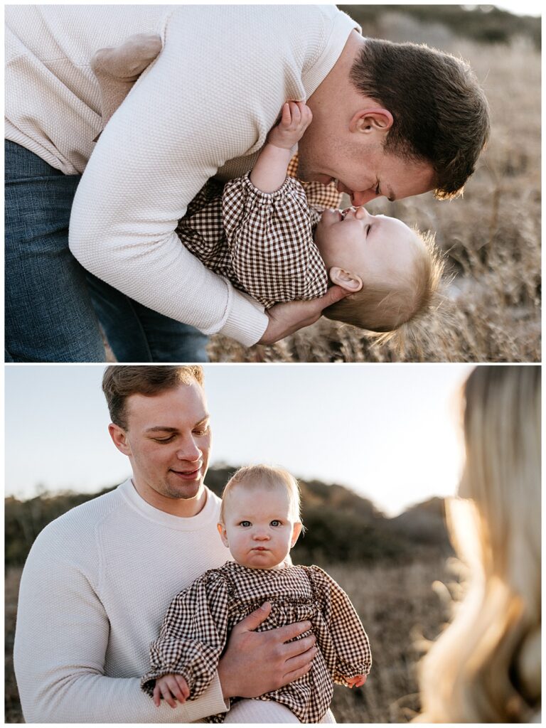 dad leans over holding toddler while nose to nose with her during beach family session